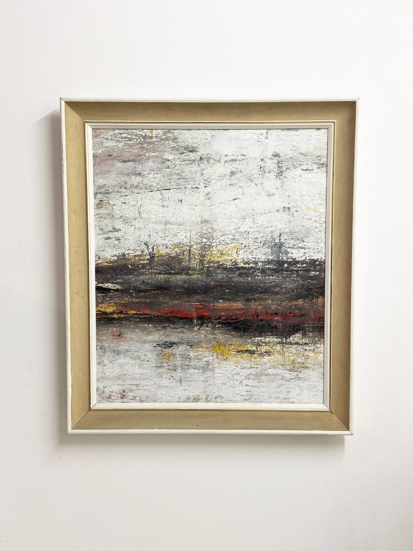 Large textured abstract acrylic painting in white, grey, earthy tones with subtle yellow and red, framed in mid-century white wood and linen.