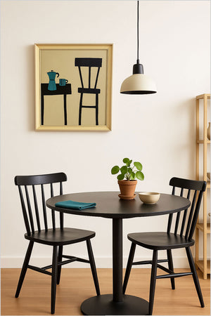 Dining area with black round table and chairs, plant, and framed artwork on the wall. Terence R. Wood, Abstract Still Life Painting, black table and chairs, blue coffee pot and striped mug. 