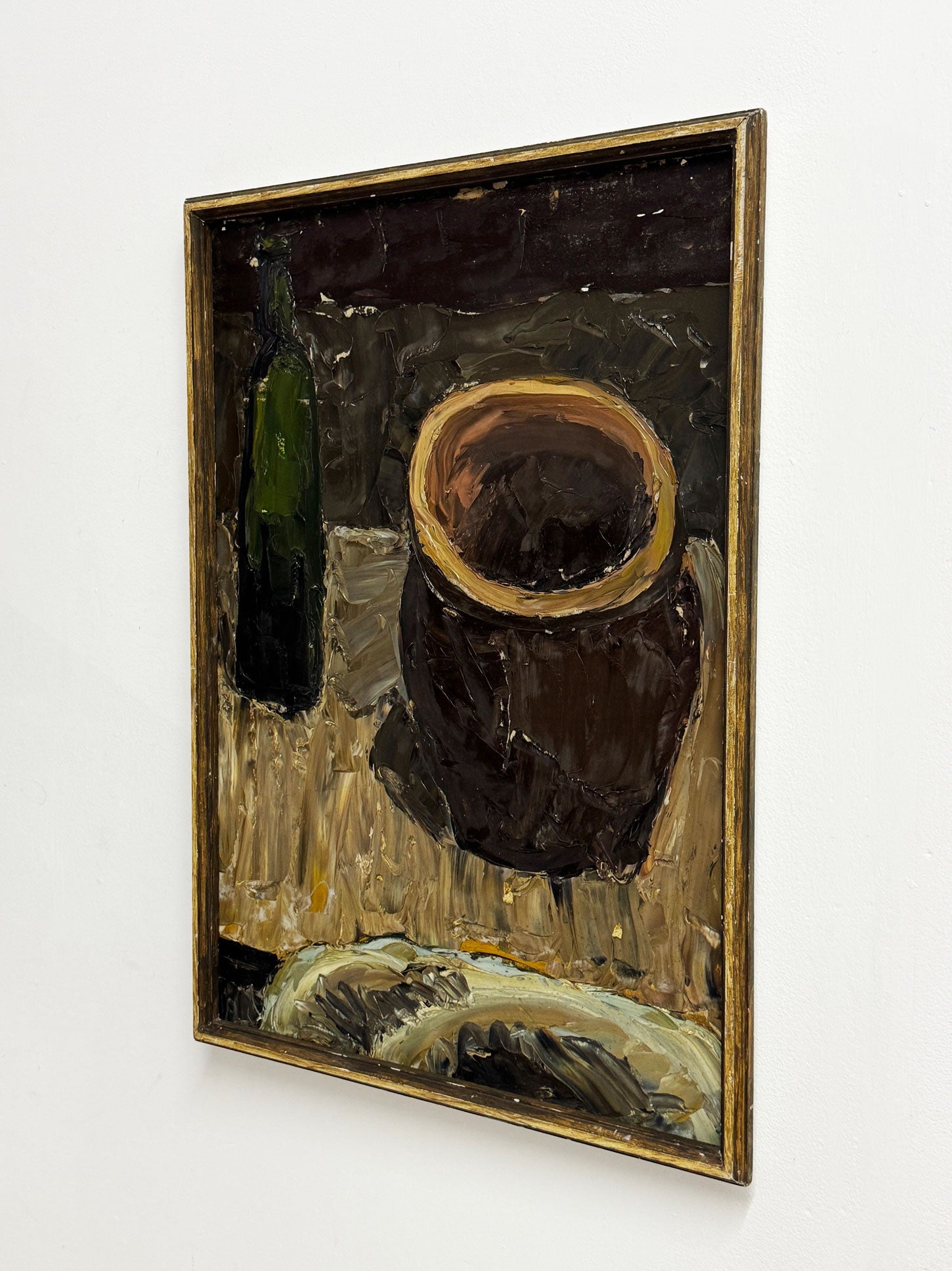 Framed painting of a still life with a dark pot and green bottle on a light surface.