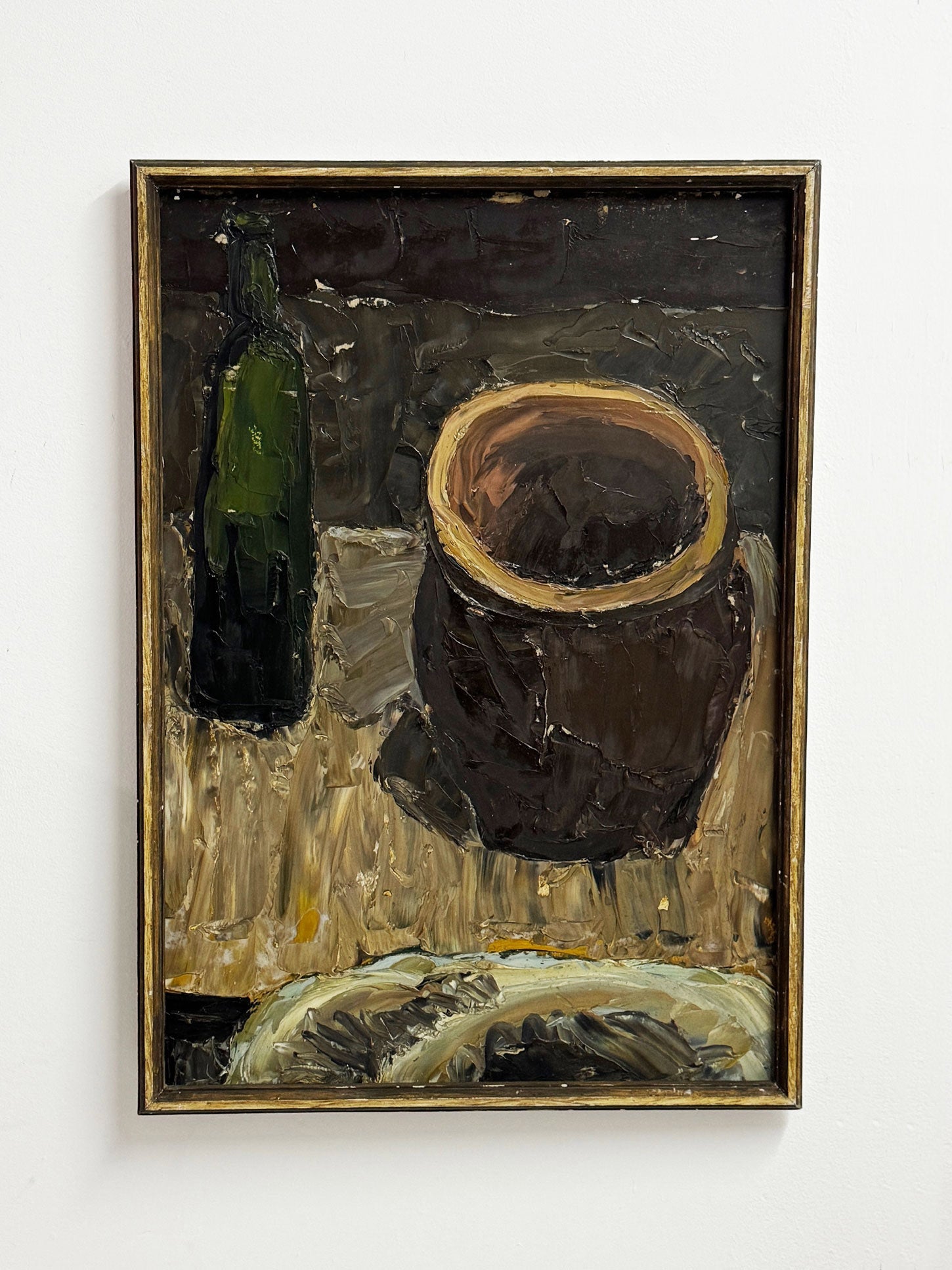 Framed painting of a still life with a dark pot and green bottle on a light surface.